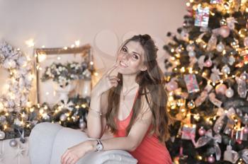 Portrait of a beautiful girl with flowing hair on the background of the Christmas tree.