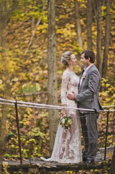 Portrait of couple in wedding attire standing on the footbridge.