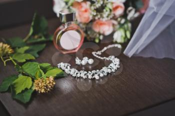 Necklace and bouquet of flowers on the table.