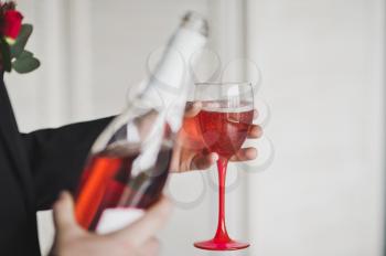Man in suit pouring wine into a glass.