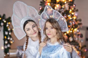 Studio portrait of two beautiful girls in fabulous costumes.