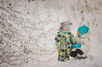 Portrait of young children on the background of snowy winter forest.