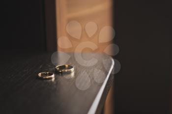 Two gold rings on the varnished table.