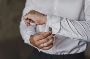 The man pulls out a box of cuff links.