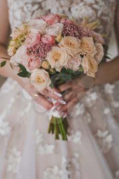 Delicate bouquet of flowers in womens hands.