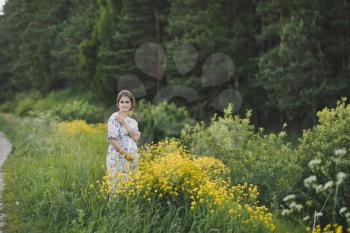 The beauty of the female figure in a forest glade of yellow flowers.