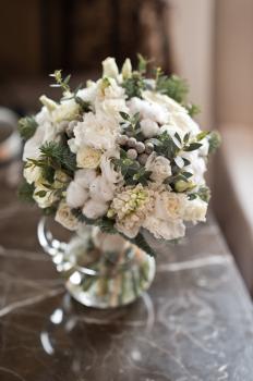 Round bouquet of white roses in a glass vase.