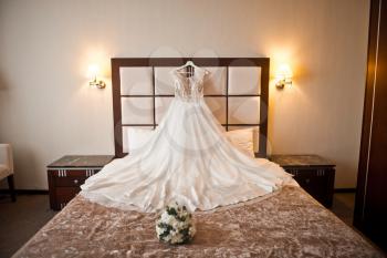 Gorgeous wedding dress bride beautifully laid out on the bed.