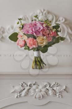 Bouquet of flowers on the background of carved decoration.