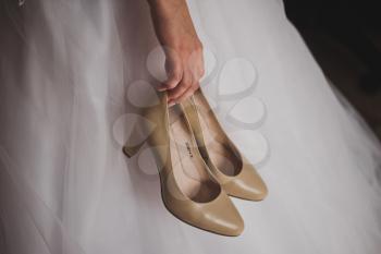 Beautiful shoes in the hands of the bride.