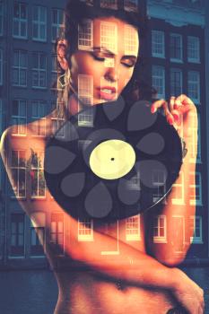 Sexy girl DJ with vinyl records in the hands of Amsterdam .Photography with double exposure
