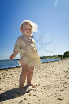 little girl playing in the sand on the beach by the sea. summer rest