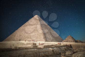 Image of the great pyramids of Giza, in Egypt. At night the stars shine.
