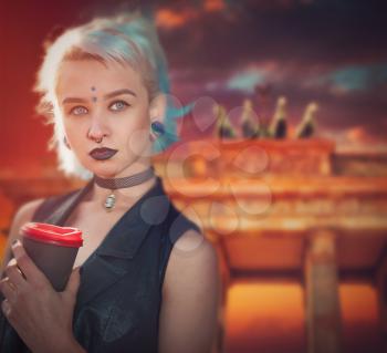 Girl with blue hair with a glass of coffee on the background of the Brandenburg Gate in Berlin