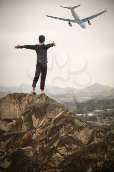 man standing on the edge of the mountain