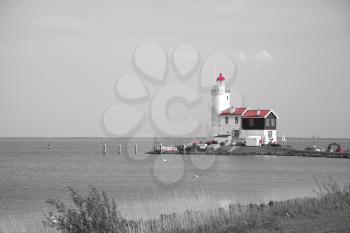 lighthouse in Marken is on the coast of the Sea in Europe. black and red and white photo