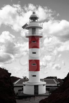 Lighthouse Punta de Teno is Tenerife on the Atlantic Ocean. black and red and white photo
