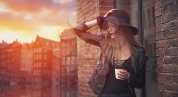 girl in a hat drinking coffee in the streets of Amsterdam, Netherlands