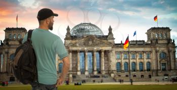 traveler with a backpack stands on the background of the Bundestag, Berlin