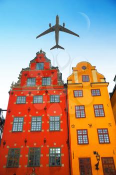 the plane flies low over the Stortorget place in Gamla stan, Stockholm Sweden.