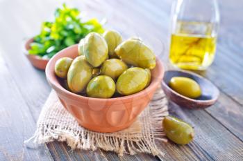 green olives in bowl and on a table