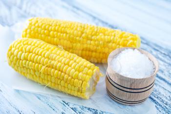 boiled corn with salt on a table