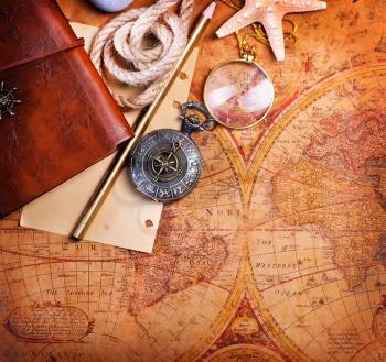 old notebook, loupe and compass on the map