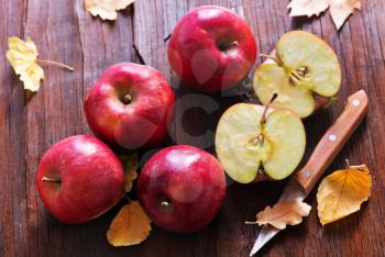 red apples and knife on the wooden table