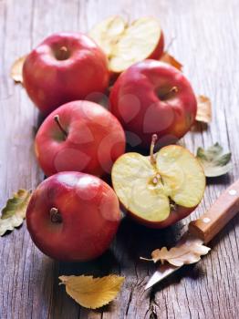 red apples and knife on the wooden table