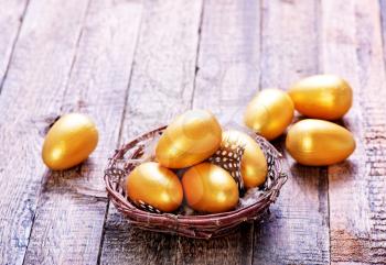 golden eggs in nest and on a table