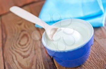 sour cream in blue bowl and on a table