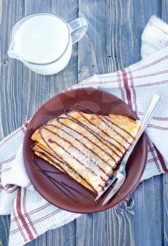 sweet pancakes with chocolate on the white plate