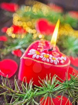 red candle and christmas decoration on the wooden table