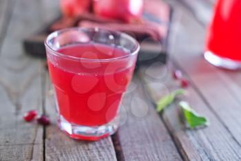 fresh pomegranate juice in glass and on a table