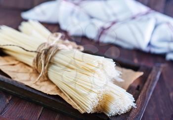 raw rice noodles on the wooden board and on a table