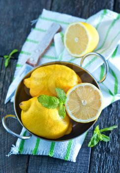 lemons in metal bowl and on a table