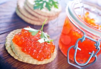 red salmon caviar in bank and on a table