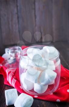 white marshmallows in glass bank and on a table