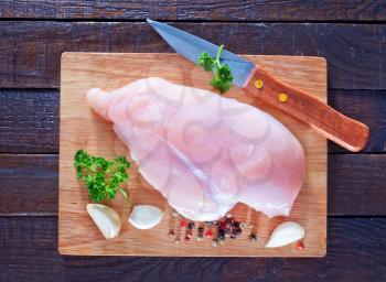raw chicken fillet on the wooden board