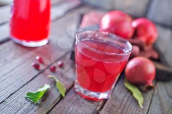 fresh pomegranate juice in glass and on a table