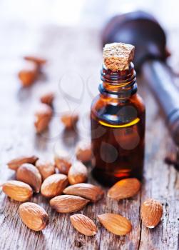 almond oil in a glass bottle with whole nuts