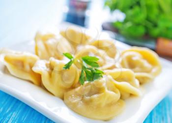 pelmeni on plate and on a table