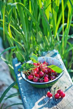 fresh cherry in bowl and on a table