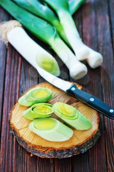 fresh leek and knife on the wooden table