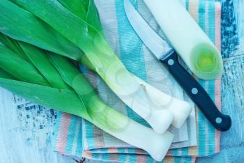 fresh leek and knife on the wooden table