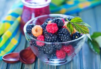 fresh berries in glass bowl and on a table