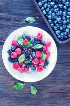 berries on white plate and on a table