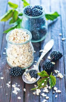 oat flakes with black berries on the wooden table