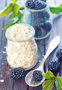 oat flakes with black berries on the wooden table