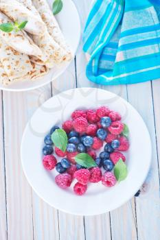 fresh berries on plate and on a table